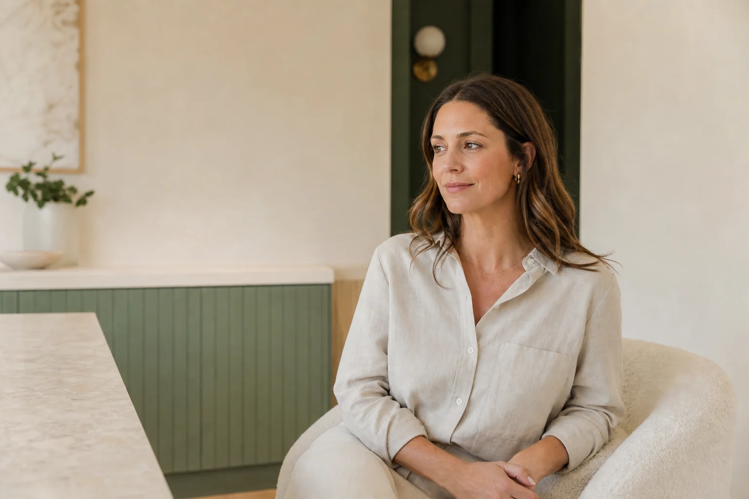 Model seated in a warm, softly lit interior.